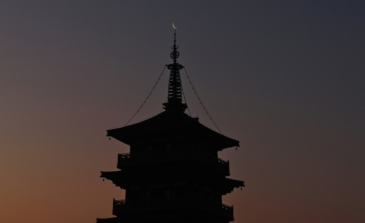 2026年1月15日，江苏扬州，一轮“最小残月”现身天宇，这也是本年度“最小残月”。其间，月球位于轨道远地点附近，人们看到的月亮像是一弯纤细的银钩。孟德龙/IC photo
