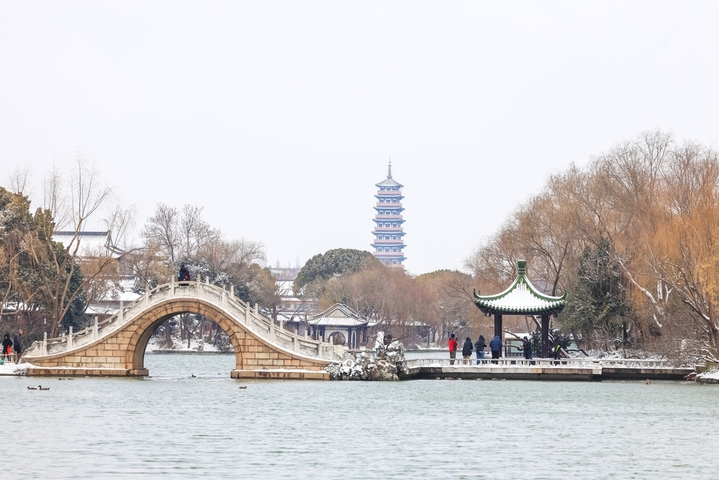 2026年1月20日，江苏扬州，2026 第一场雪落扬州，瘦西湖迎赏雪热潮。大寒节气与2026年第一场雪如约而至，瘦西湖景区被白雪轻轻覆盖，宛如披上一层晶莹的外衣。众多游客踏雪而来，在银装素裹的湖光山色间拍照留影，定格属于扬州冬日的浪漫瞬间。