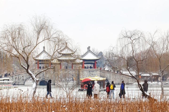 2026年1月20日，江苏扬州，2026 第一场雪落扬州，瘦西湖迎赏雪热潮。大寒节气与2026年第一场雪如约而至，瘦西湖景区被白雪轻轻覆盖，宛如披上一层晶莹的外衣。众多游客踏雪而来，在银装素裹的湖光山色间拍照留影，定格属于扬州冬日的浪漫瞬间。陈扬/IC photo