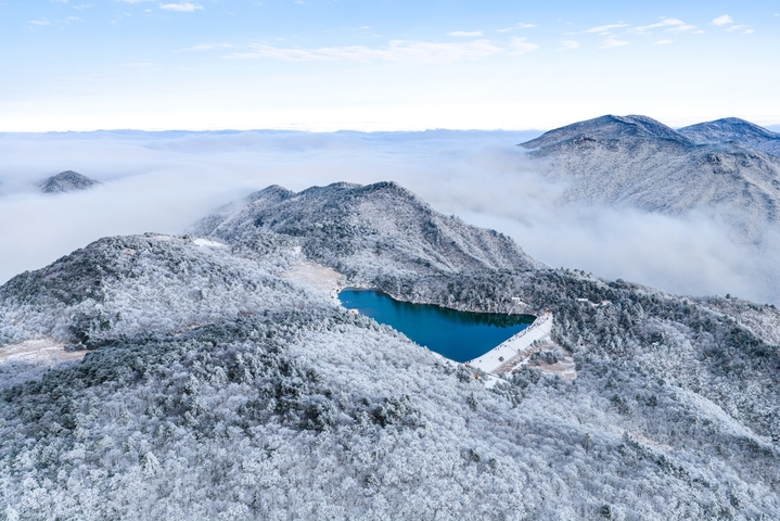 2026年1月21日，杭州临安百丈岭迎来雪后晴天，群山银装素裹，湖水碧蓝如镜，游客沿湖赏雪、拍照、露营，尽享高山雪景与自然静谧之美。IC photo