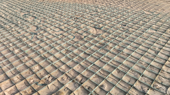 2026年1月22日，在甘肃省酒泉市金塔至大墩门公路两侧连绵起伏的沙丘上，千亩阻沙网与草方格交织成一道道的 “沙海防线”，昔日随风移动的沙丘被牢牢锁住。来源：曹红祖/IC photo

