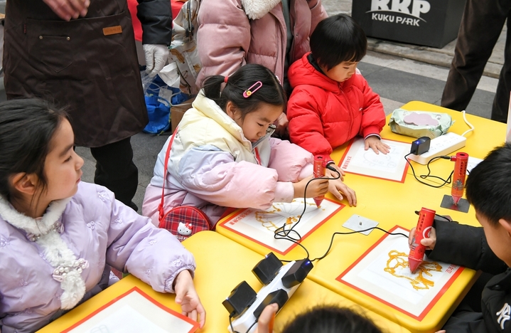 2026年1月25日，安徽省“我们的节日——欢欢喜喜过大年”2026春节主题文旅活动在合肥市蜀山区新粮仓街区举行。图为小朋友在制作非遗糖画。
