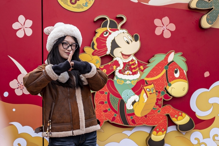 2026年1月28日，上海迪士尼乐园，游客与新春主题墙合影。
