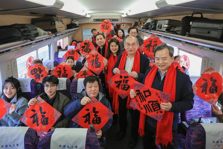 2026年2月1日，在G8388次长三角超级“环线”列车上，来自长三角地区的十余名书法家接力登车，现场为旅客书写“福”字，喜迎新春佳节。签约供稿人/IC photo