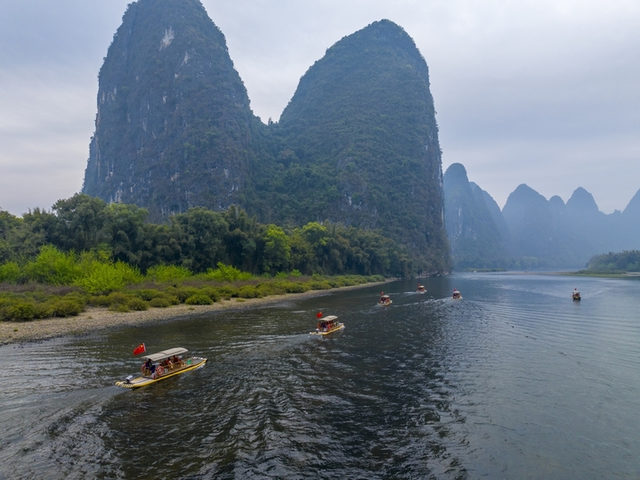 2026年3月17日，广西桂林市阳朔县兴坪古镇段漓江上，游客乘坐竹筏畅游漓江。春日的漓江宛如一幅流动的山水画卷。青峰倒影在澄澈江面，两岸翠竹随风轻摆，游客们在舟行碧波上的惬意中，沉浸式感受喀斯特山水的灵动秀美。何华文/IC photo