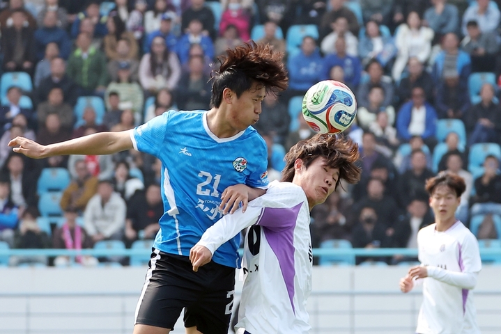 2026年3月25日，江苏常州，江苏常州与湖南永州足球友谊交流赛在常州奥体中心体育场举行，最终，常州队1比0战胜永州队。比赛过程中，双方球员拼劲十足，观赛球迷热情高涨。图为常州队球员（白衣）与永州队球员（蓝衣）在比赛中拼抢。