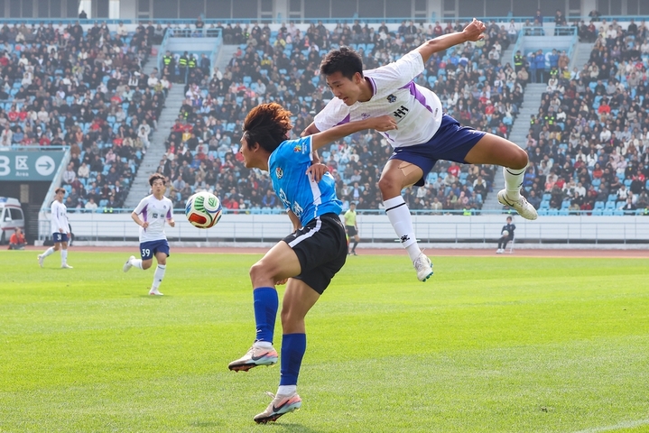 2026年3月25日，江苏常州，江苏常州与湖南永州足球友谊交流赛在常州奥体中心体育场举行，最终，常州队1比0战胜永州队。比赛过程中，双方球员拼劲十足，观赛球迷热情高涨。图为常州队球员（白衣）与永州队球员（蓝衣）在比赛中拼抢。来源：IC photo
