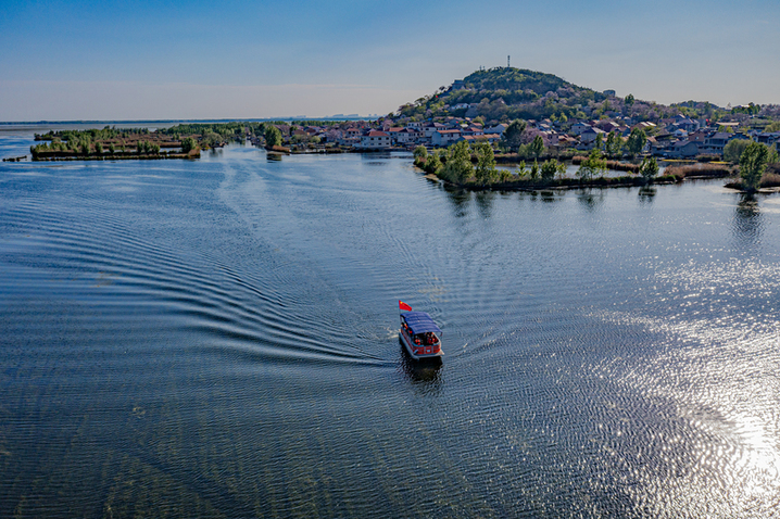 2026年4月12日，山东微山，游客乘船在独山湖游览湖景，打卡“水下森林”风光。视觉中国