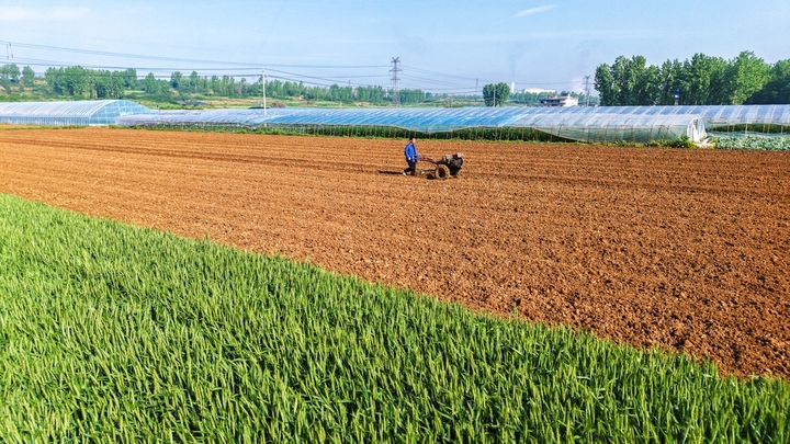 2026年4月17日，河南省南阳市卧龙区潦河镇李庄村，村民驾驶农机在田间进行起垄作业，为种植西瓜做好准备。
