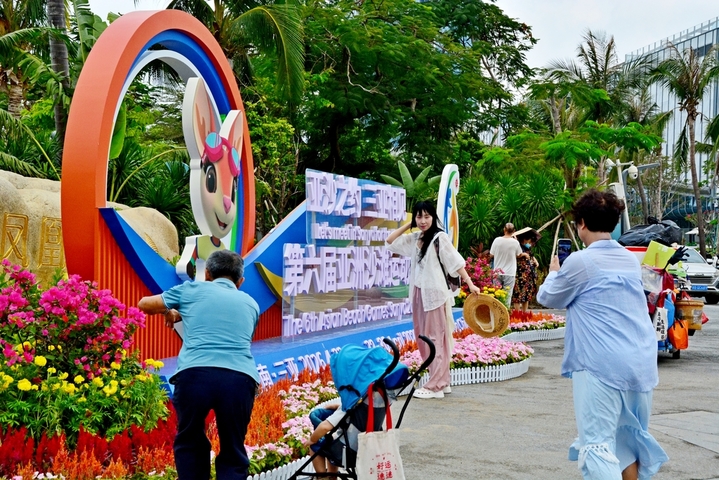 2026年4月21日，海南三亚，第六届亚洲沙滩运动会即将在海南三亚市举行，凤凰岛桥头公园前，市民及游客纷纷与亚沙会宣传标志留影，以此留做纪念。来源：IC photo