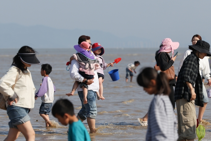  2026年5月3日，游客带着孩子在江苏省连云港市赣榆海州湾旅游度假区乘坐马车游玩。“五一”假期，人们走出家门，尽享假日时光。来源：司伟/IC photo


