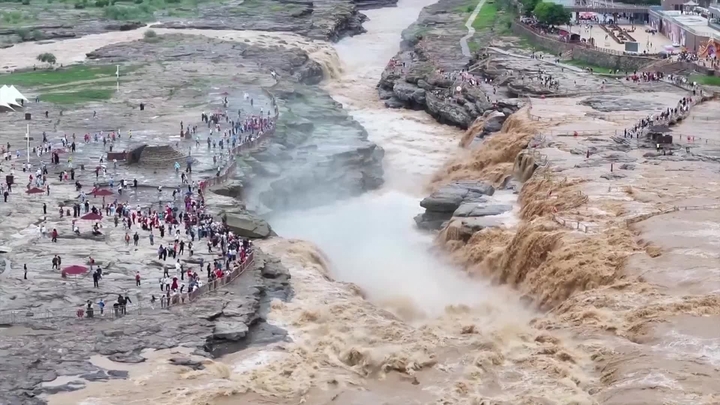 （视频截图）2026年5月25日，游客在山西省临汾市吉县黄河壶口瀑布旅游景区欣赏“金瀑飞流”壮美景观。日前，受黄河上游持续降雨影响，地处秦晋大峡谷的该景区水量骤增，瞬时流量超900立方米/秒，吸引众多游客慕名观赏。